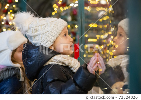 Happy kids examining toys in shop window together Happy kids examining toys in shop window together 72324020
