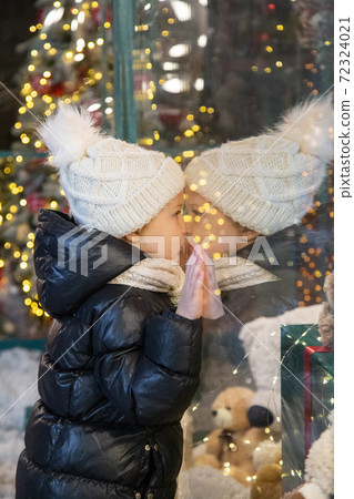 Curious child examining toys in shop window Curious child examining toys in shop window 72324021