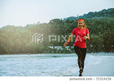 asian woman jogging workout on the beach in the morning. Relax with the beach. fun and happy with playing, jumping, kicking the sea. in summer asian woman jogging workout on the beach in the morning. Relax with the beach. fun and happy with playing, jumping, kicking the sea. in summer 72324256