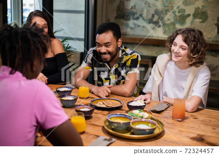 Multi-ethnic group of friends having a good time in a cafe 72324457