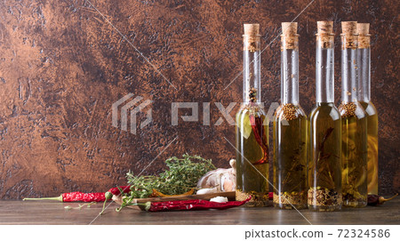 Bottles of olive oil with different spices and herbs. Bottles of olive oil with different spices and herbs. 72324586