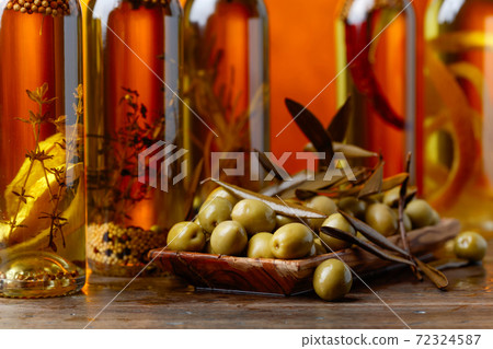 Green olives and bottles of olive oil . 72324587
