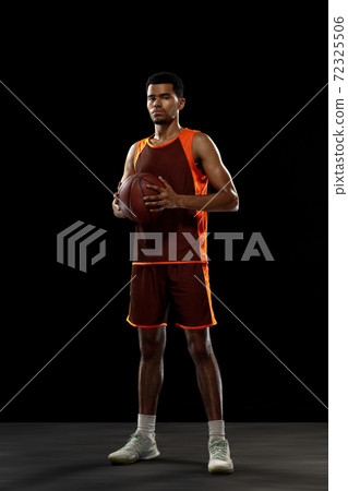 Young african basketball player training on black studio background. Young african basketball player training on black studio background. 72325506
