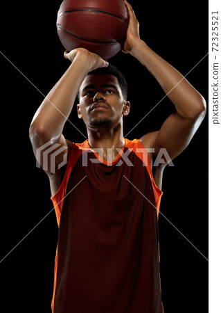Young african basketball player training on black studio background. 72325521