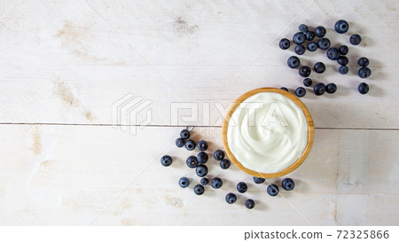 White yoghurt with ripe blue fruit on a table with copy space White yoghurt with ripe blue fruit on a table with copy space 72325866