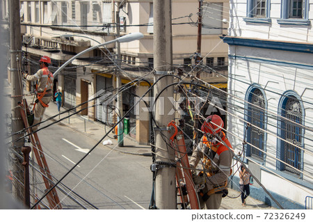 Men repairing electrical grid wires using masks because of COVID-19 Men repairing electrical grid wires using masks because of COVID-19 72326249