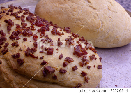 Fresh home baked breads, make out of wheat, one simple and one with pepperoni on top Fresh home baked breads, make out of wheat, one simple and one with pepperoni on top 72326344