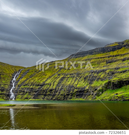 Waterfall and lake under dark stormy clouds Waterfall and lake under dark stormy clouds 72326651