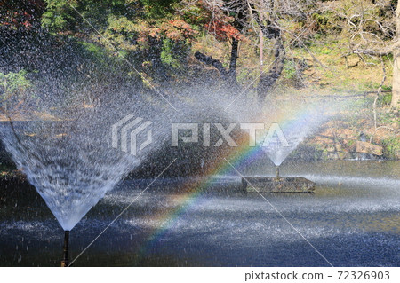 A fountain with a rainbow 72326903