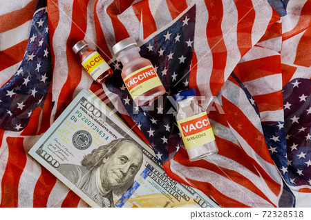 American vaccine coronavirus SARS-COV-2 COVID-19 to fight in the coronavirus pandemic with the US dollar currency USA flag in the background American vaccine coronavirus SARS-COV-2 COVID-19 to fight in the coronavirus pandemic with the US dollar currency USA flag in the background 72328518