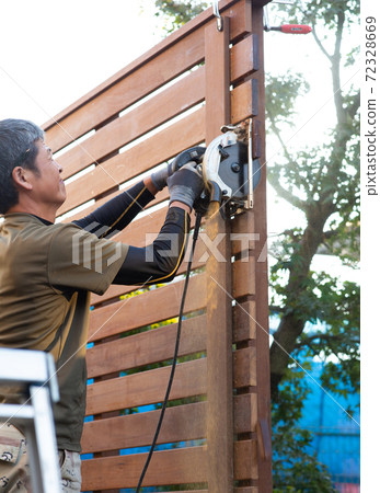 Carpenter making a fence 72328669