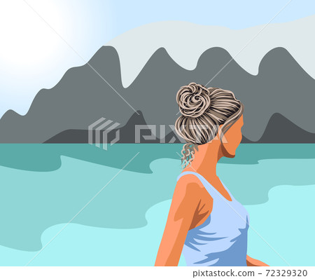 Gray haired woman in blue tank top looking at the lake and the mountains 72329320