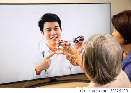 Elderly woman using physical therapy online service at home. Elderly woman using physical therapy online service at home. 72329453