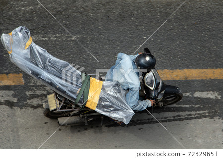 A man transports excessive cargo on a motorcycle, Saigon, Vietnam. 72329651