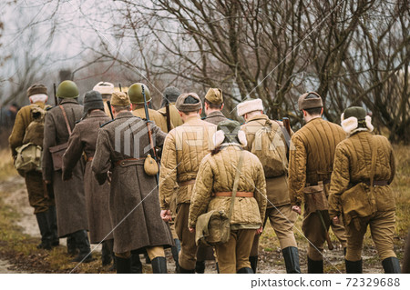 Re-enactors Dressed As World War II Russian Soviet Red Army Soldiers Marching Through Forest. Soldier Of WWII WW2 Times Re-enactors Dressed As World War II Russian Soviet Red Army Soldiers Marching Through Forest. Soldier Of WWII WW2 Times 72329688