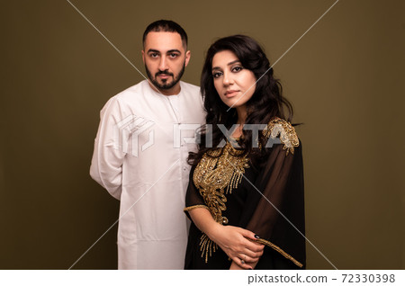 Muslim woman and man. Close up Portrait of a young arab girl and man in traditional dress. Muslim woman and man. Close up Portrait of a young arab girl and man in traditional dress. 72330398