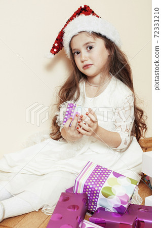 little cute girl in santas red hat waiting for Christmas gifts. holiday lifestyle people concept 72331210