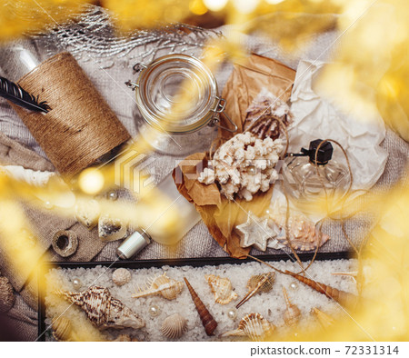 a lot of sea theme in mess like shells, candles, perfume, girl stuff on linen, pretty textured post card view vintage 72331314