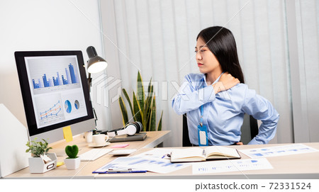 Asian female accountant is tired from working in a chair, stretching to relax and relax while working hard at the office 72331524