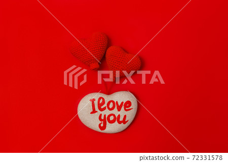 stone with inscription I love you and two knitted heart shaped balls on red background stone with inscription I love you and two knitted heart shaped balls on red background 72331578