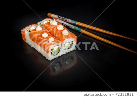 Sushi Sets Uramaki, California, Philadelphia, on a white plate. Festive, New Year concept. Against a dark reflective background. Sushi Sets Uramaki, California, Philadelphia, on a white plate. Festive, New Year concept. Against a dark reflective background. 72331931