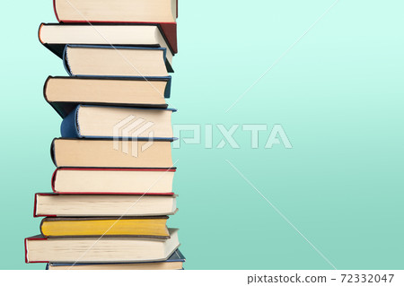 Pile of books stacked on a blue background with space for copy Pile of books stacked on a blue background with space for copy 72332047