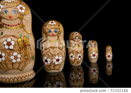 Wooden Russia matrioshka dolls in a row on a blackground Wooden Russia matrioshka dolls in a row on a blackground 72332188