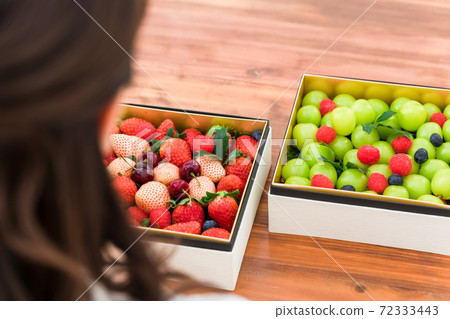 A woman staring at a fruit like a jewelry box 72333443
