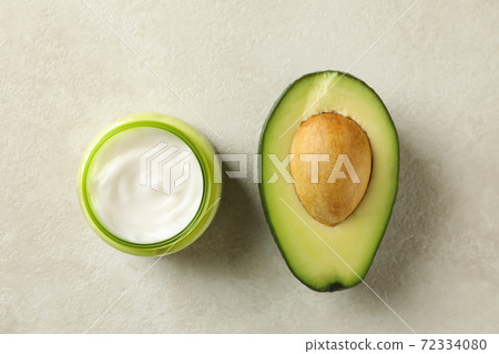 Jar of cosmetic cream and avocado, top view 72334080
