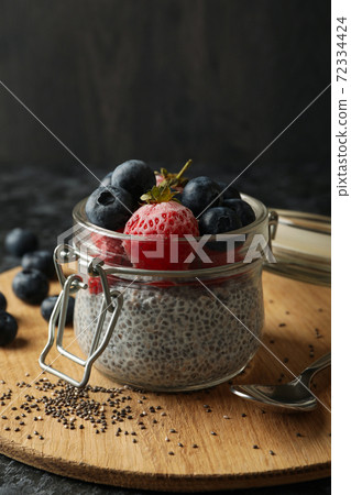 Board with jar of delicious chia pudding on black smokey table Board with jar of delicious chia pudding on black smokey table 72334424