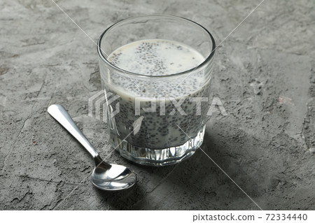 Spoon and glass with chia pudding on gray background Spoon and glass with chia pudding on gray background 72334440