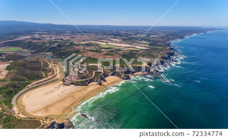 Aerial panorama of the village and Odeceixe beach, in summer overlooking the Algarve. Portugal  72334774
