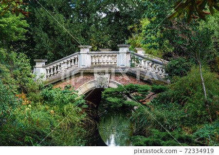 Stone arch bridge over a stream in the Parc Monceau - Paris, France 72334919