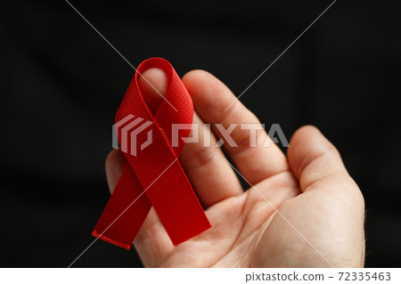 red AIDS ribbon on the hand 72335463