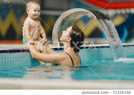 Mother and little son enjoying swimming in a swimming pool Mother and little son enjoying swimming in a swimming pool 72336198