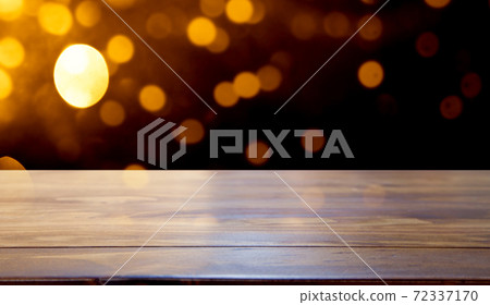 empty wooden desk space and Christmas lights in the background 72337170