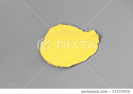 Smear of yellow clay on gray background. 72337650