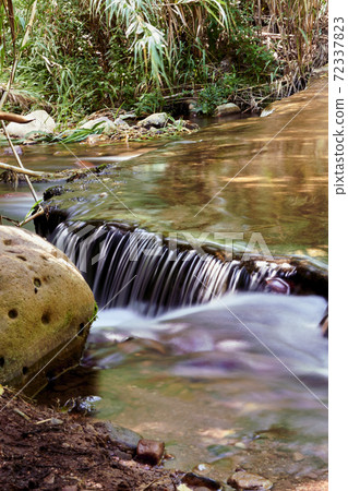 Small waterfall in a mountain river Small waterfall in a mountain river 72337823
