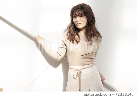Young woman leaning on the railing of the stairs Young woman leaning on the railing of the stairs 72338143