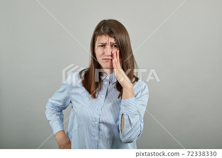 Touching mouth with hand painful expression because of toothache or dental Touching mouth with hand painful expression because of toothache or dental 72338330