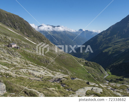 Green mountain valley with Nurnberger Hutte mountain hut, peaks and spring at Stubai hiking trail, Stubai Hohenweg, Summer rocky alpine landscape of Tyrol, Stubai Alps, Austria 72338682
