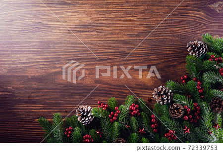 Christmas branches decoration concept with berries, stars and pine cones on old wooden background. Flat lay, top view with copy space. Christmas branches decoration concept with berries, stars and pine cones on old wooden background. Flat lay, top view with copy space. 72339753