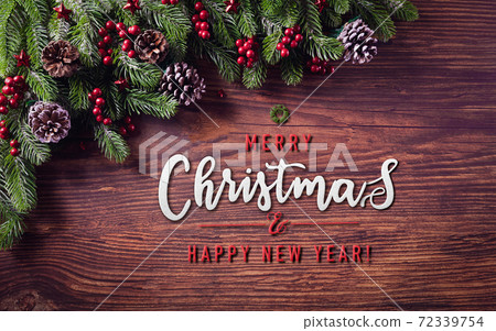 Christmas branches decoration concept with berries, stars and pine cones on old wooden background Christmas branches decoration concept with berries, stars and pine cones on old wooden background 72339754