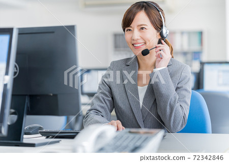 Young female operator working in the office Young female operator working in the office 72342846