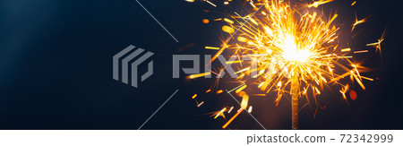 shiny fire sparkler on dark blue background shiny fire sparkler on dark blue background 72342999