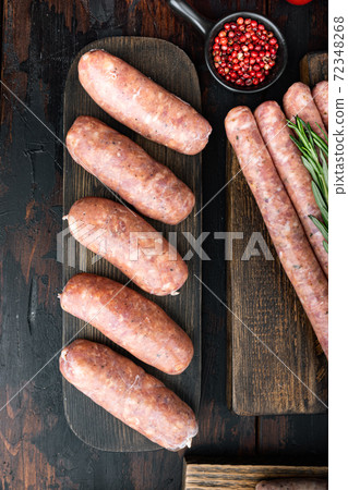 Raw pork sausages, top view, on old dark wooden background 72348268