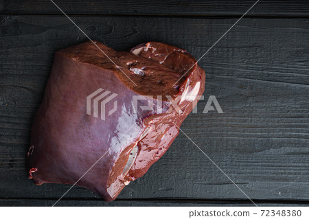 Beef liver on black wooden background, top view with copy space Beef liver on black wooden background, top view with copy space 72348380