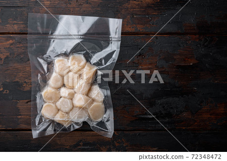 Scallops in vacuum pack, top view, on dark wooden background with copy space Scallops in vacuum pack, top view, on dark wooden background with copy space 72348472