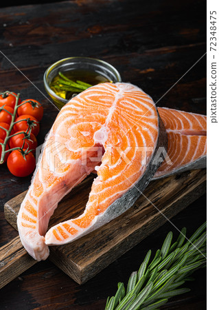Slice of red fish salmon with herbs, on old wooden table Slice of red fish salmon with herbs, on old wooden table 72348475