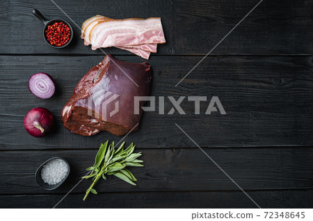 Raw liver with bacon and onion on black wooden background, flat lay with copy space Raw liver with bacon and onion on black wooden background, flat lay with copy space 72348645